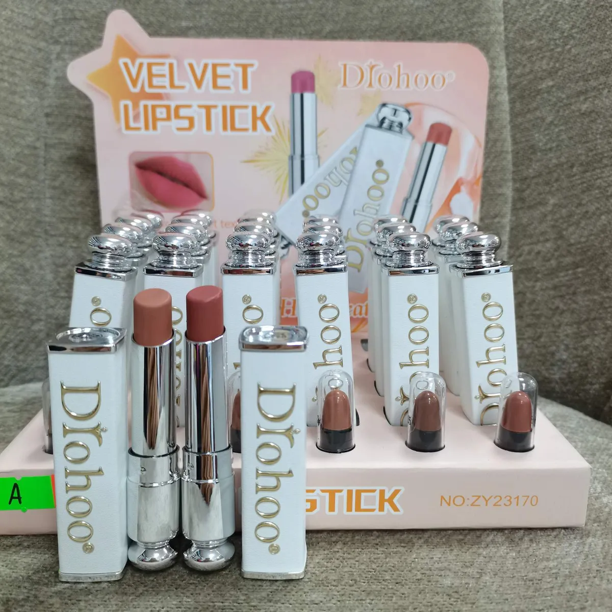 Pomadki Dłohoo Velvet Lipstick w białych opakowaniach z metalicznym srebrnym wykończeniem i złotym logo