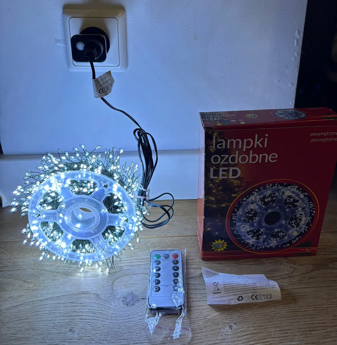 Lampki choinkowe LED zimny biały na zielonym druciku, zwinięte na plastikowej szpuli, pilot i opakowanie
