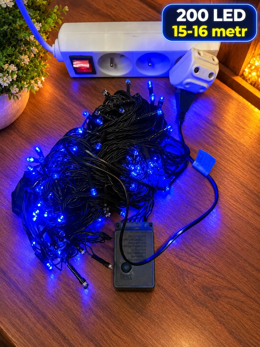 Lampki choinkowe LED z 200 niebieskimi diodami na czarnym przewodzie, podłączone do listwy zasilającej