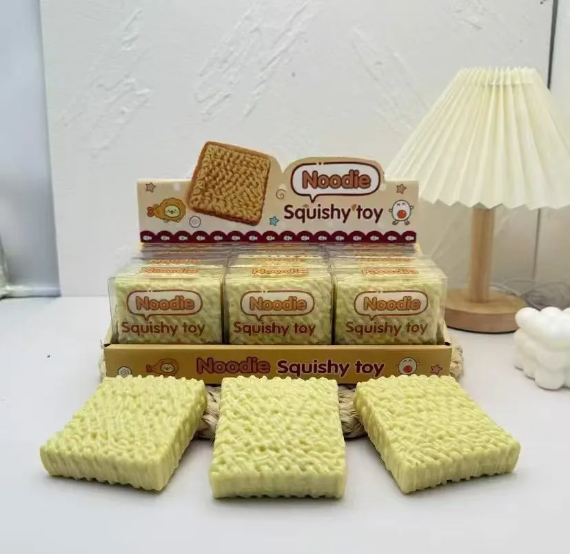 żółta miękka zabawka antystresowa Noodie Squishy Toy o fakturze makaronu instant w przezroczystym opakowaniu