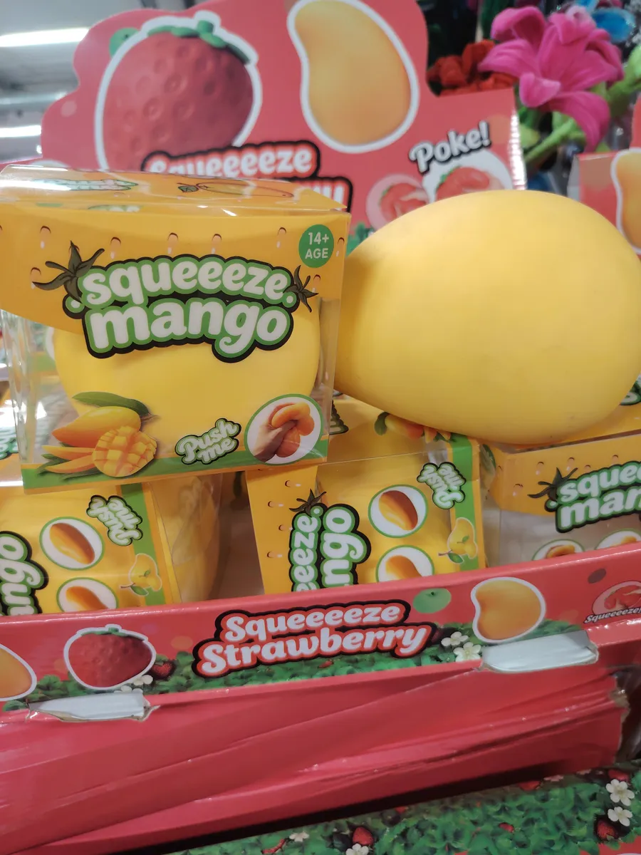 Żółta gniotka antystresowa w kształcie mango w opakowaniu z napisem Squeeeze Mango