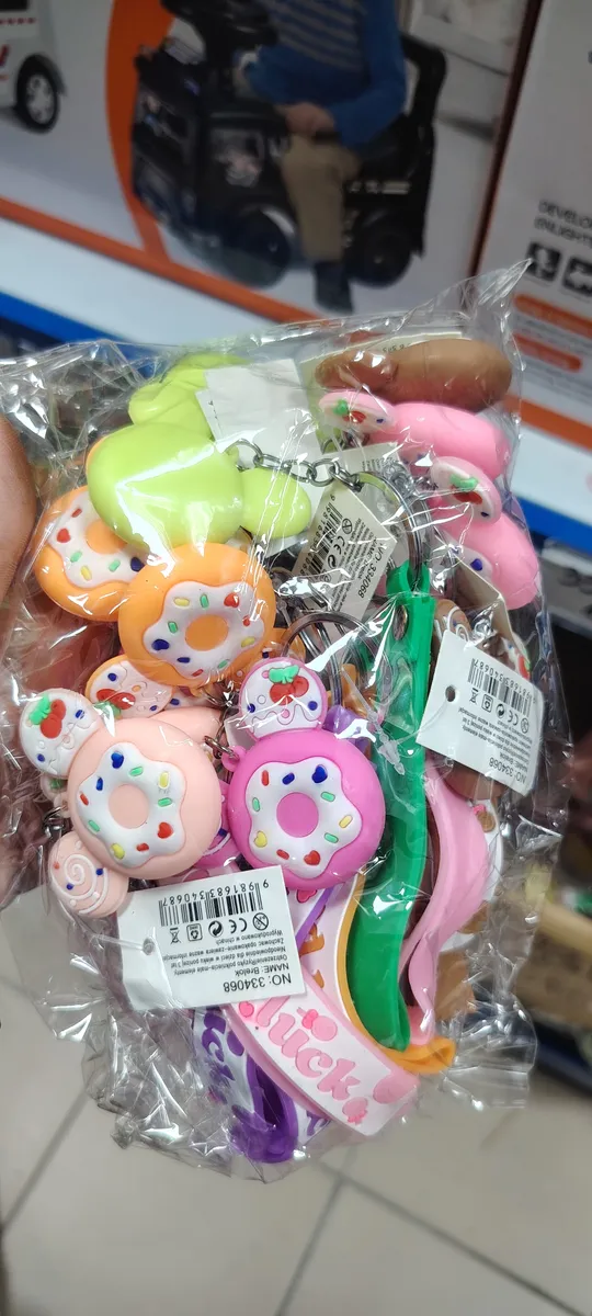 Zestaw kolorowych breloków z motywem pączków i owoców w przezroczystym opakowaniu plastikowym