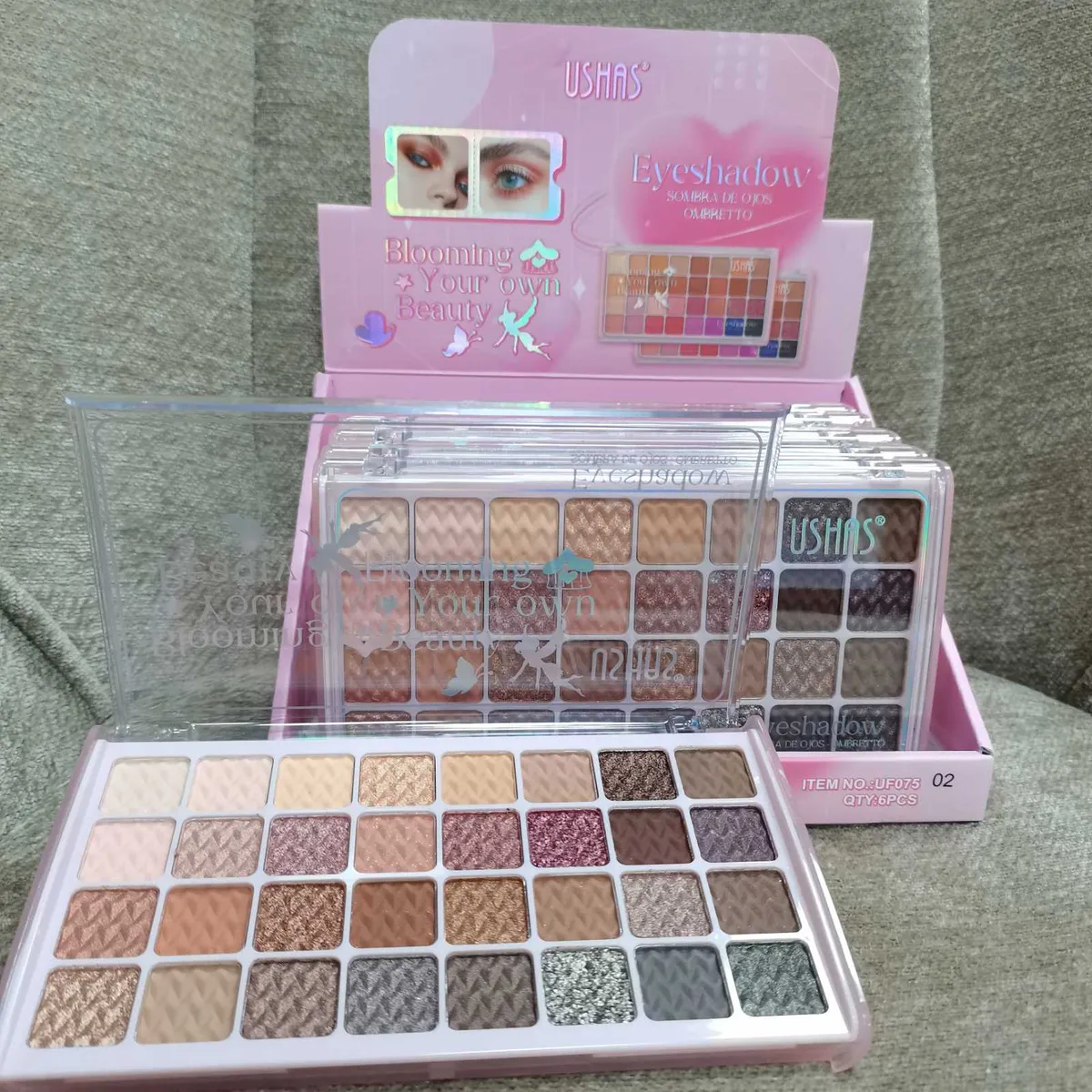 Paleta cieni do powiek USHAS z 35 kolorami w opakowaniu z przezroczystą pokrywą na tle różowego displayu