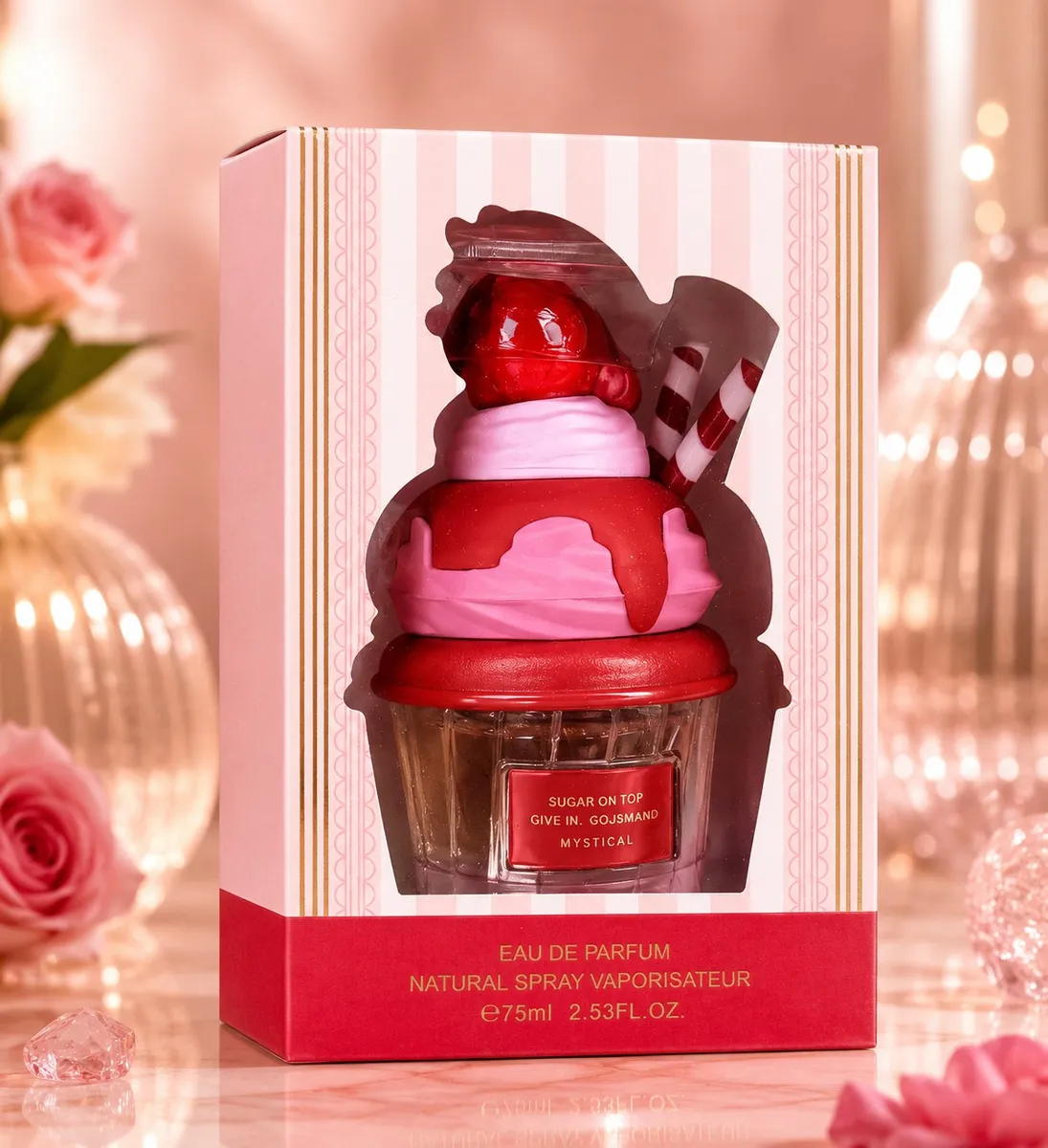 Perfumy w butelce przypominającej deser z truskawką i laskami w różowo-czerwonym opakowaniu