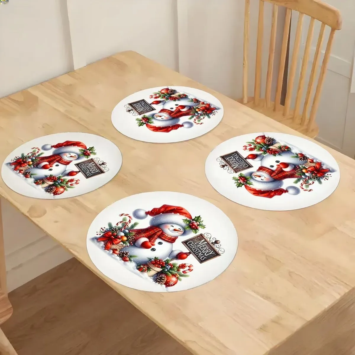 Cztery okrągłe podkładki na stół z motywem bałwanka i napisem Merry Christmas na drewnianym stole